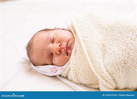 Newborn Baby With Milia On Face Sleeping Swaddled In Blanket Stock
