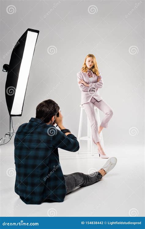 Back View Of Photographer Sitting And Photographing Beautiful Female