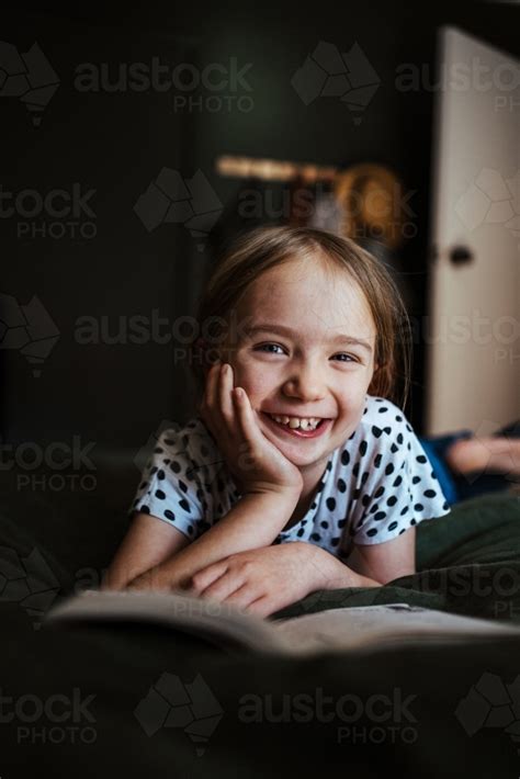 Image Of Young Girl Reading A Book At Home Austockphoto