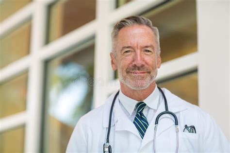 Portrait Of A Mature Handsome Doctor At A Medical Office Stock Image