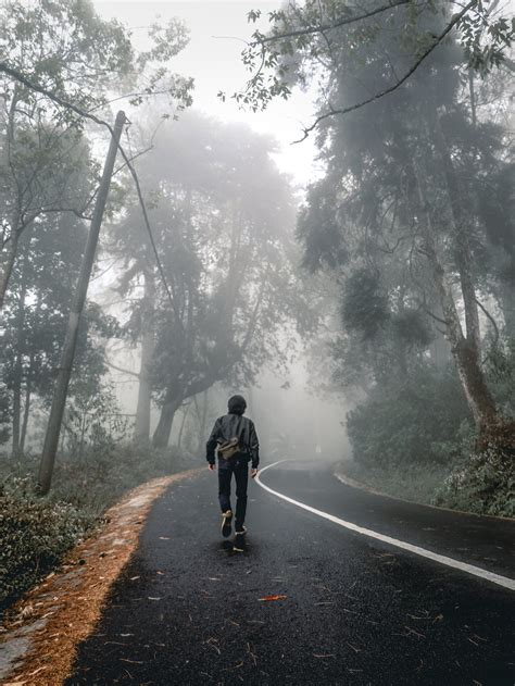 Man In Black Jacket Walking On Road During Foggy Weather · Free Stock Photo