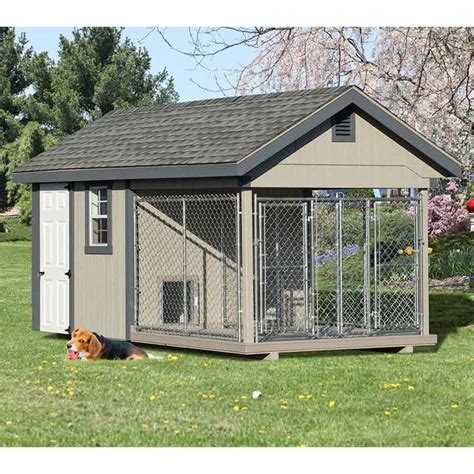 A Dog Is Laying In The Grass Next To A Small House With A Fence Around It
