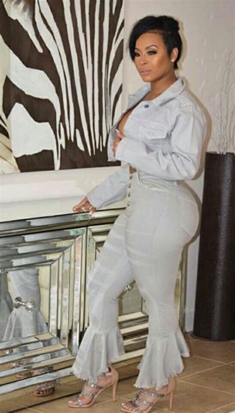 A Woman Standing In Front Of A Mirror Wearing White Pants And Heels With Her Hands On Her Hips