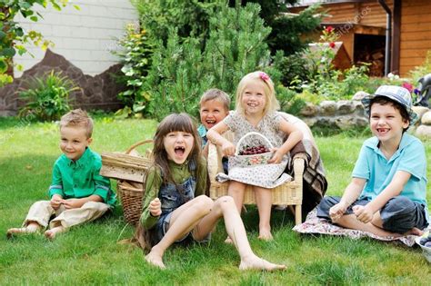 Group Of Happy Children Playing Outdoors In Park Stock Photo By