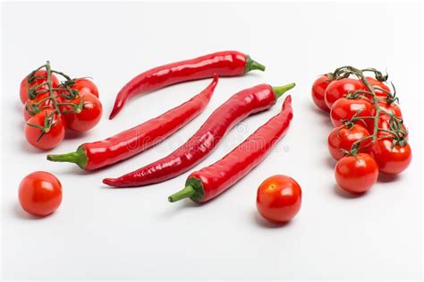 Juicy Red Hot Chili Peppers With Cherry Tomatoes On A Branch Stock