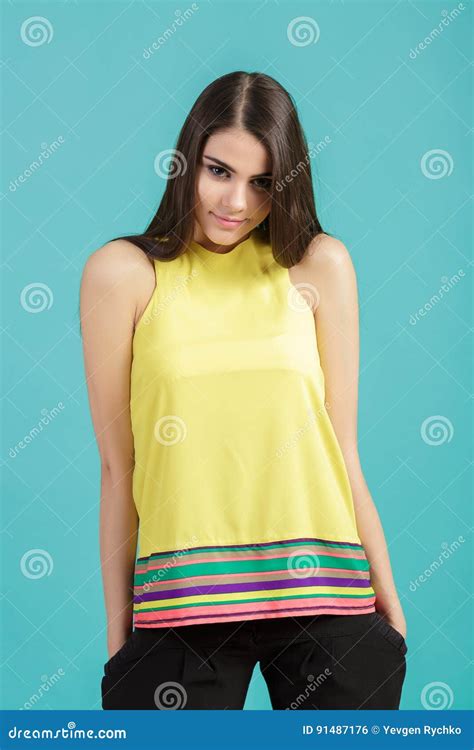 Portrait Of Young Beautiful Smiling Girl In Yellow Shirt On Blue