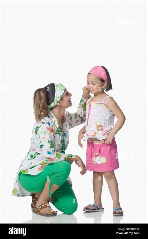 Side Profile Of A Young Woman Pinching Her Daughters Cheek Stock Photo