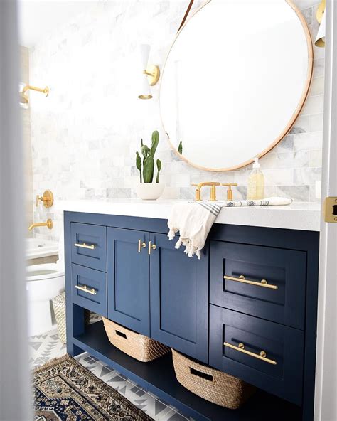 Modern Bathroom Design Featuring A Blue Vanity And Gold Accents This