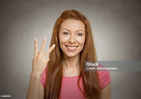 Young Woman Giving Three Fingers Gesture With Hand Stock Photo