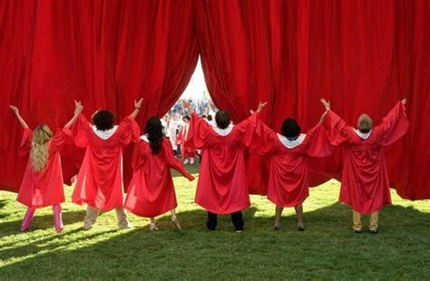 Some People Are Standing In Front Of Red Curtains With Their Hands Up