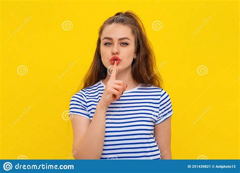 Attractive Brunette Girl Holding Index Finger At Her Mouth Making