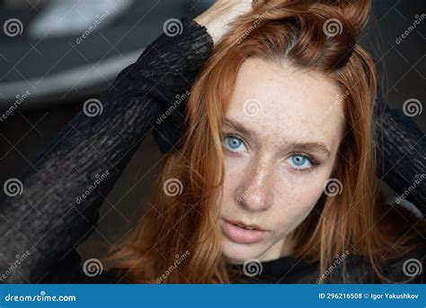 Portrait Of A Young Beautiful Woman With Red Hair And Blue Eyes In The