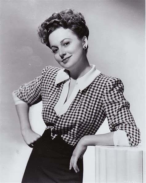An Old Black And White Photo Of A Woman Leaning On A Pedestal With Her Hands On Her Hips