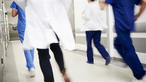 Nurses And Medical Staff Are Running Down A Hospital Hallway