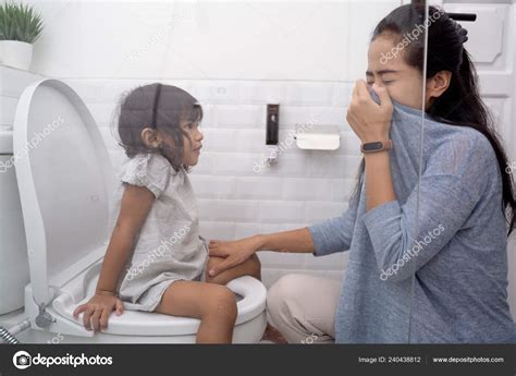 Mom Helping Her Daughter In Toilet Stock Photo By Odua