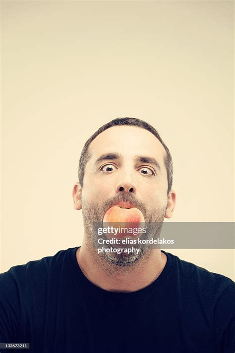 Man Holding Apple In His Mouth High Res Stock Photo Getty Images