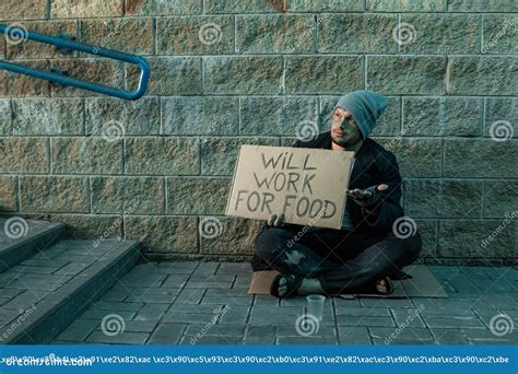 A Man Homeless A Man Asks For Alms On The Street With A Sign Will