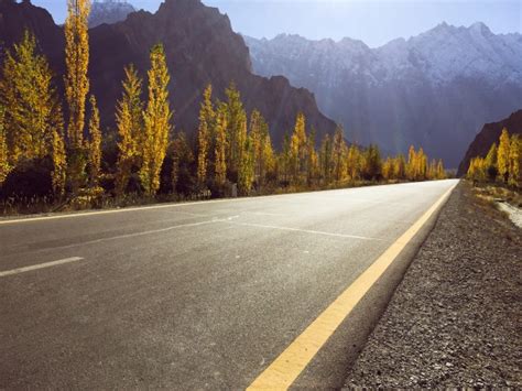 Premium Photo An Empty Paved Road On Karakoram Highway Against Snow