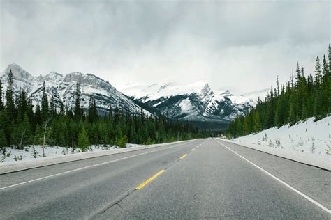 Road With Snow Capped Mountains With Trees And Landscape In Jasper