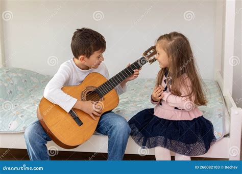 Hermano Tocando Guitarra Para Su Hermana Familia Feliz Imagen De