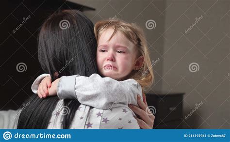 Child Is Crying In Room In The Arms Of His Mother A Loving Young
