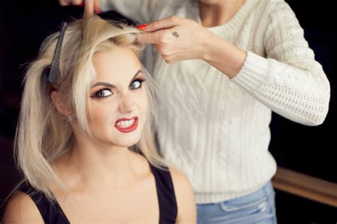 Blonde Joven Hermoso El Artista De Maquillaje Hace El Pelo Foto de archivo Imagen de cosmético
