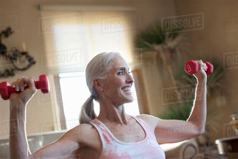 Older Woman Lifting Weights At Home Stock Photo Dissolve