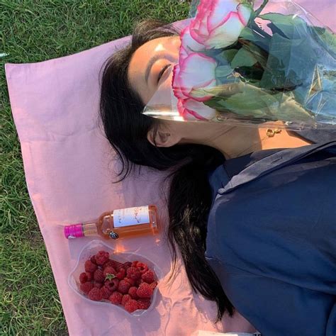 A Woman Laying On Top Of A Pink Towel Next To A Bag Of Raspberries
