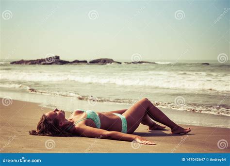 Young Woman Is Lying On The Beach Against The Background Of Sea And Stones Stock Image Image