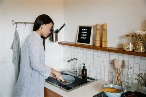 Focused Asian Woman Washing Dishes · Free Stock Photo