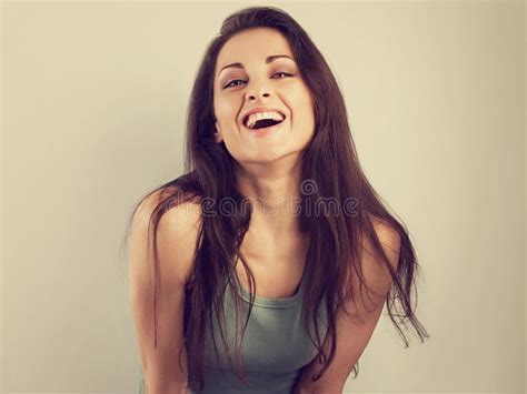 happy laughing beautiful woman covering the face the hands on blue background and happy looking