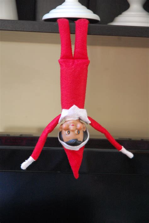 An Elf Hanging Upside Down On A Shelf