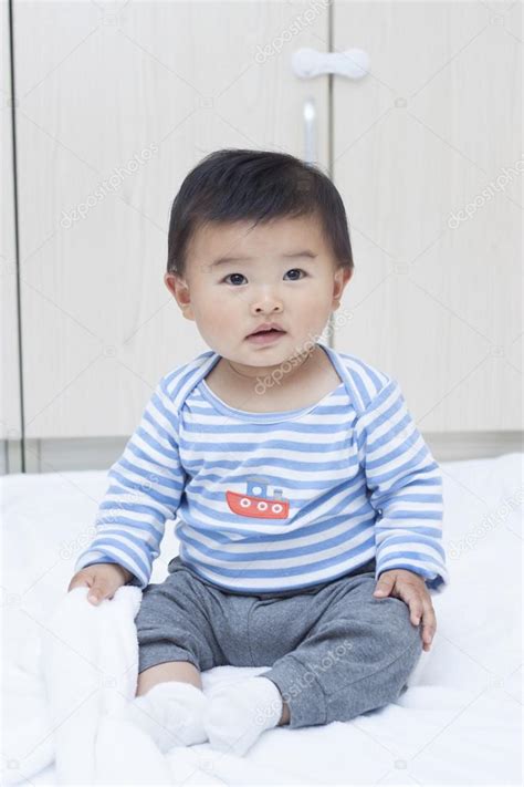 Cute Chinese Baby Boy Sitting On A White Blanket Stock Photo By