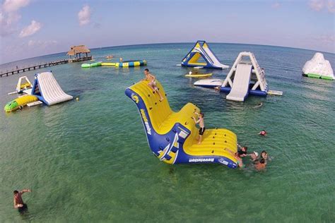 People Are Swimming In The Water Near An Inflatable Chair And Other