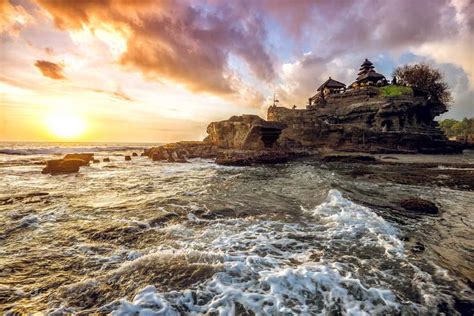 The Sun Is Setting Over An Ocean With Waves Crashing In Front Of Some