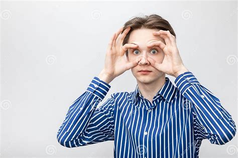 Teenager Holding Eyes Open Wide Studio Shot On Gray Background Stock