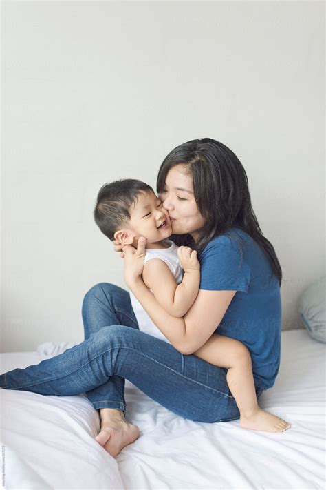 Young Asian Mother Kissing Her Son Stocksy United