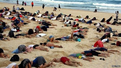 Demonstrators Take Part In A Protest By Burying Their Heads In The Sand