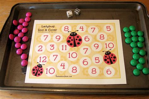 A Ladybug Roll And Cover Game On A Tray With Pink And Green Balls
