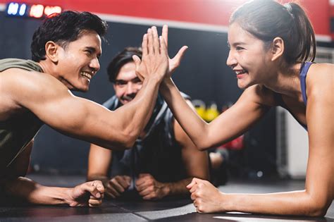 Woman And Man Friends High Fiving Exercise While Planking On A Fitness