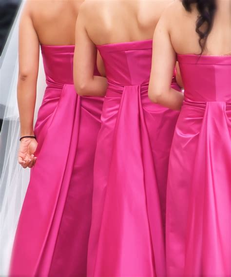 These Three Bridesmaids Are Wearing Bright Pink Bridesmaids Strapless