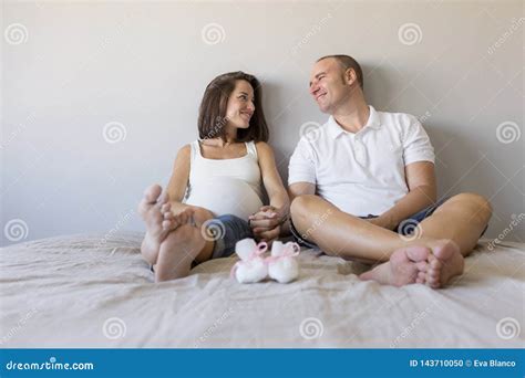 Beautiful Pregnant Woman And Her Handsome Husband Are Hugging And Smiling While Spending Time