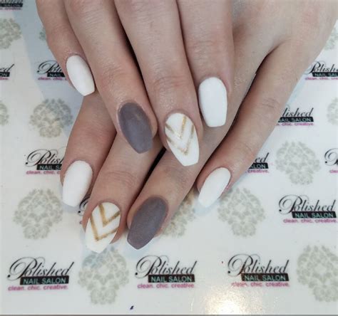 A Womans Hands With White And Brown Manies On Their Nails Holding