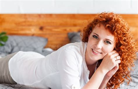Attractive Red Haired Curly Girl Lies Resting On The Bed Stock Image Image Of Room Beauty