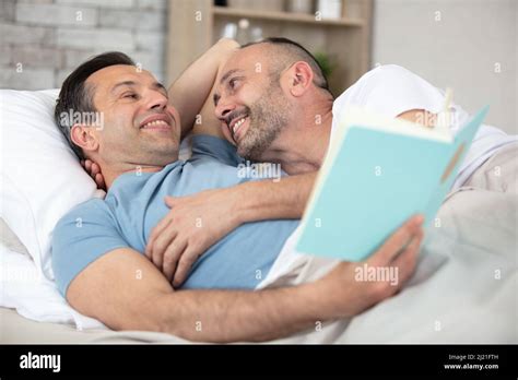 Happy Gay Couple Lying On Bed At Home Stock Photo Alamy