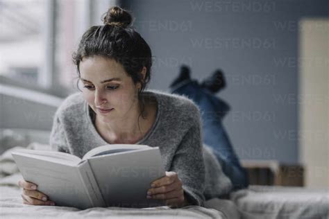 Portrait Of Young Woman Reading Book At Home Stock Photo