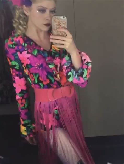 A Woman Is Taking A Selfie With Her Cell Phone While Wearing A Colorful