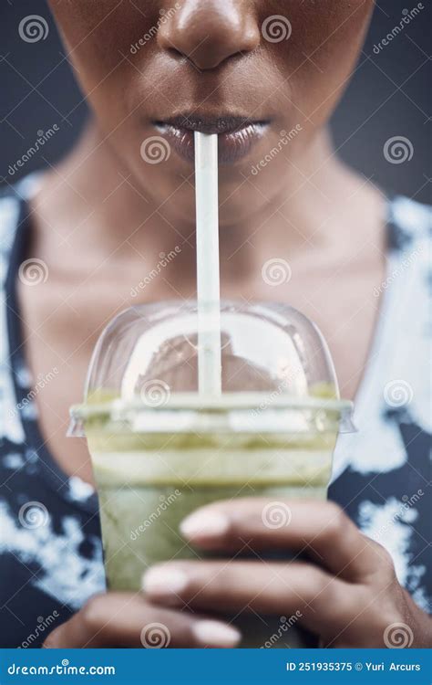 Closeup Of One Active Woman Drinking A Healthy Green Detox Smoothie While Exercising Outdoors