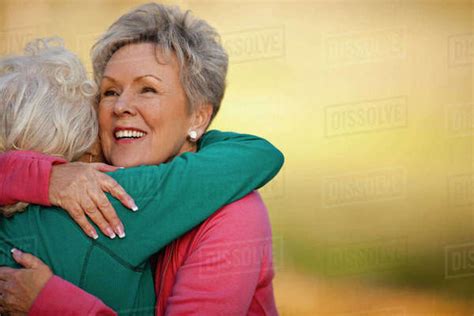 Smiling Senior Woman Hugging Her Friend Stock Photo Dissolve