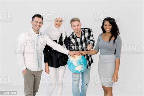Multiethnic Group Of Young People Holding Hands On The Earth Globe And